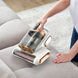Actual cordless vacuum on a fabric sofa